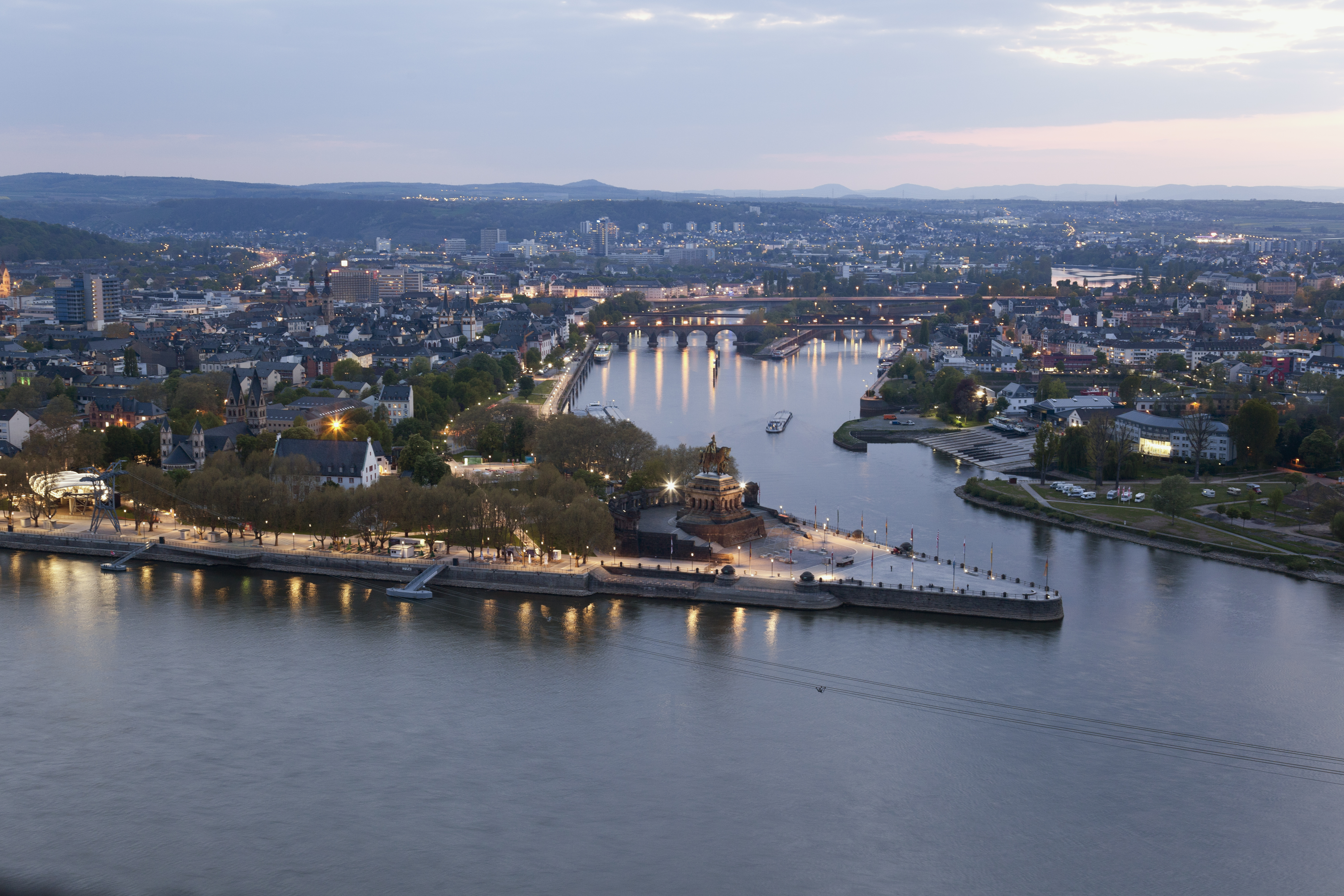 Luftblick des deutschen-Eck am Abend. Links und Rechts des dreickigen Denkmals verläuft ein Fluss.