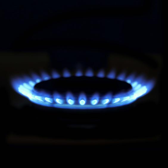 Blaue Gasflamme auf schwarzem Hintergrund.