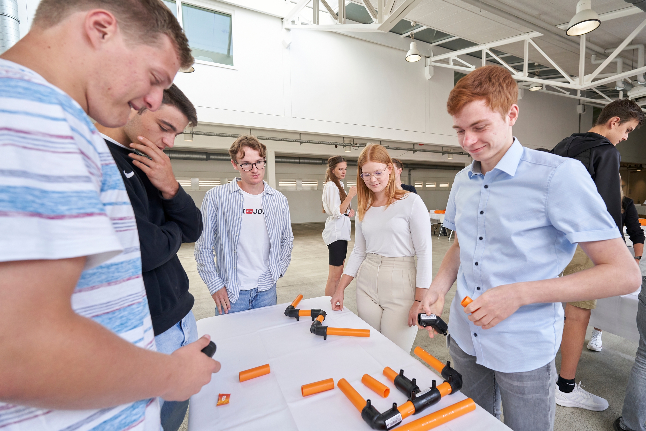 Mehrere junge Menschen stehen um einen Tisch herum