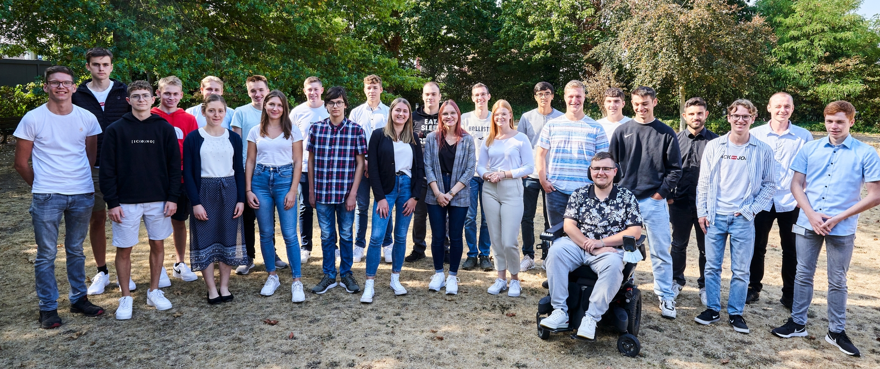 Mehrere junge Menschen stehen zusammen und lächeln freundlich