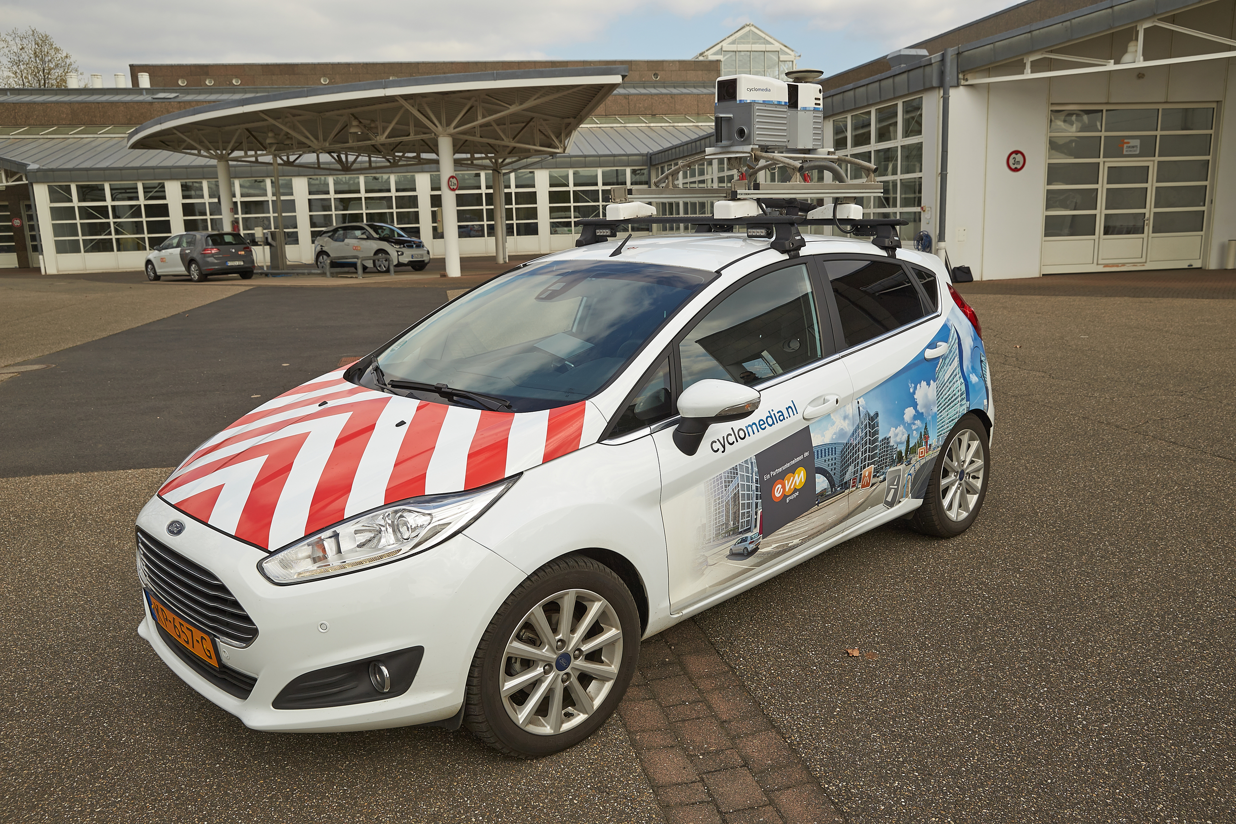 Ein Auto mit rot-weißen Streifen und einer Kamera auf dem Dach