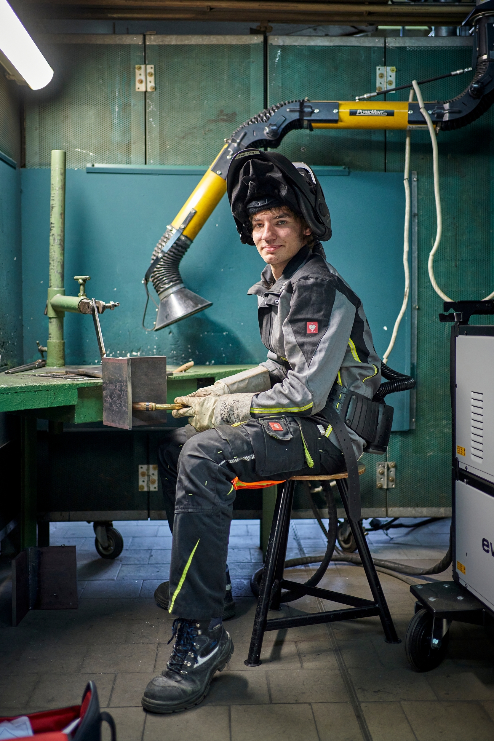 Ein junger Mann mit Schutzkleidung schweisst etwas.