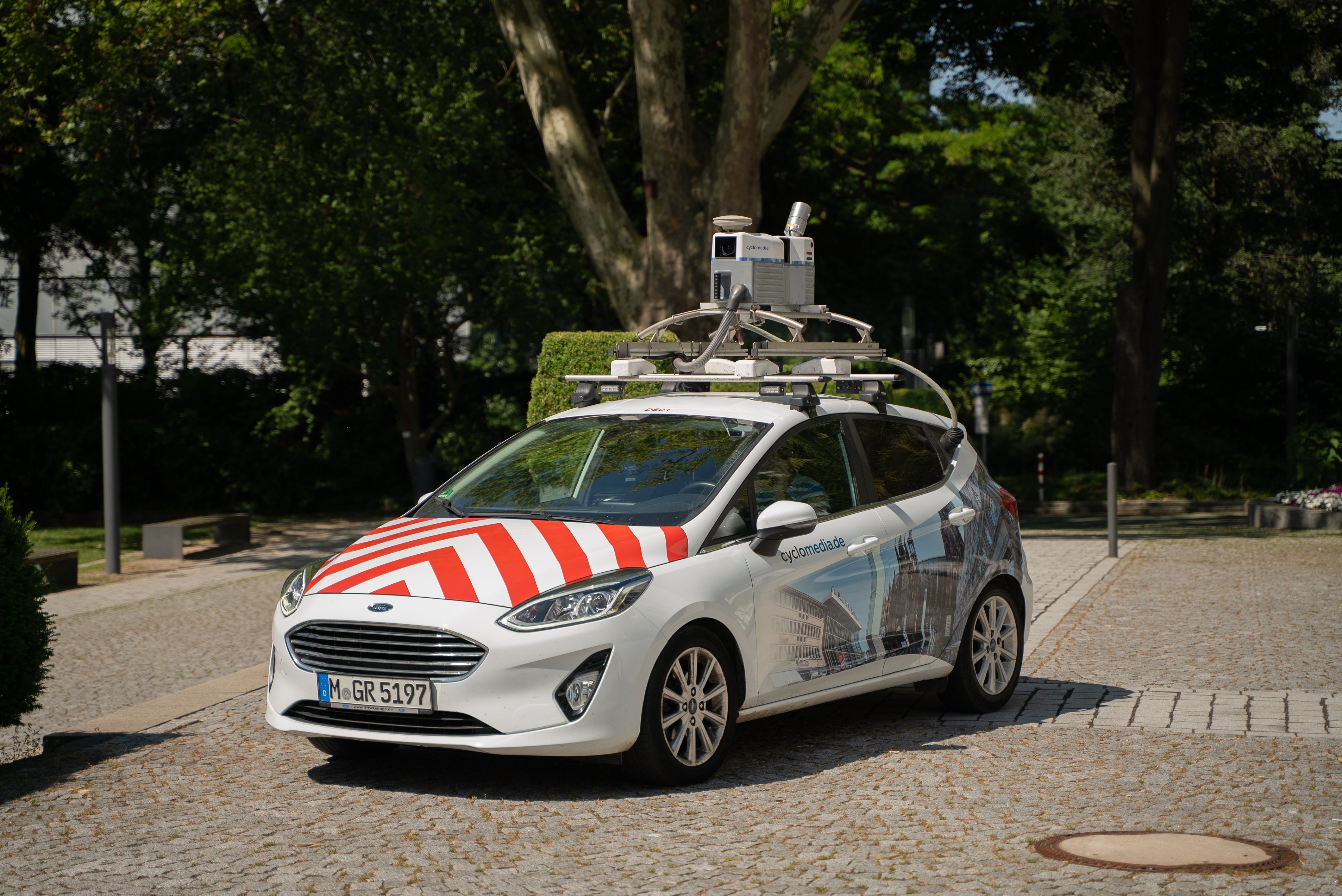 Ein Auto mit rot-weißen Streifen und einer Kamera auf dem Dach