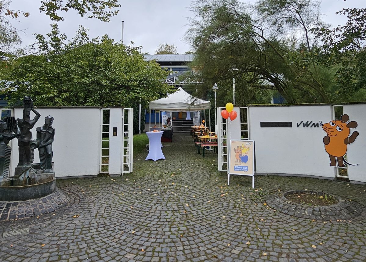 Eingang des Wasserwerks. Links eine orangene Maus aus der Sendung mit der Maus.