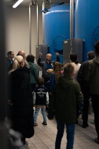 Wasserwerk-24 Ein Mann führt mehrere Menschen und Kinder durch ein Wasserwerk