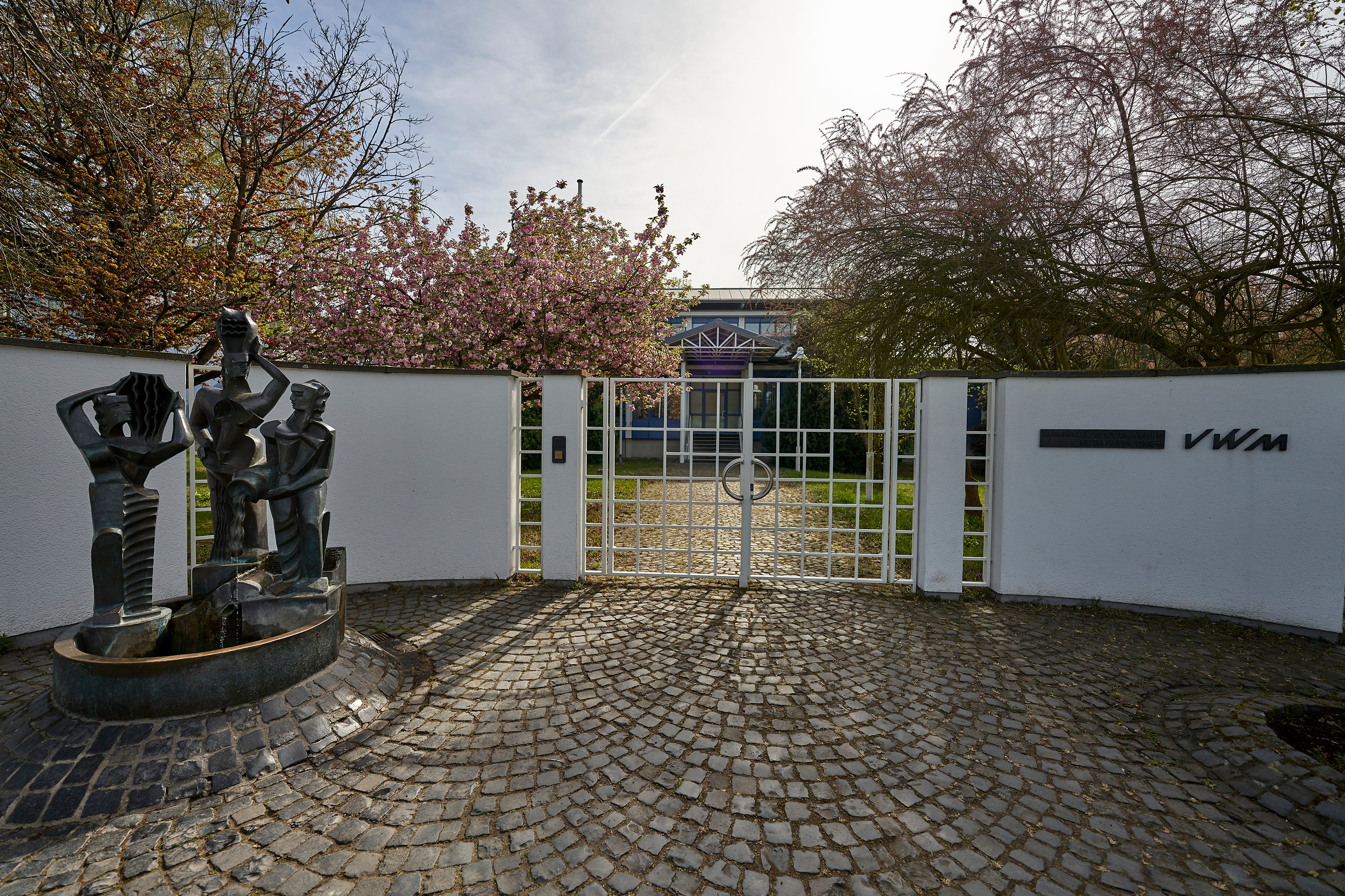 Eingang eines Wasserwerks. Links steht ein Brunnen